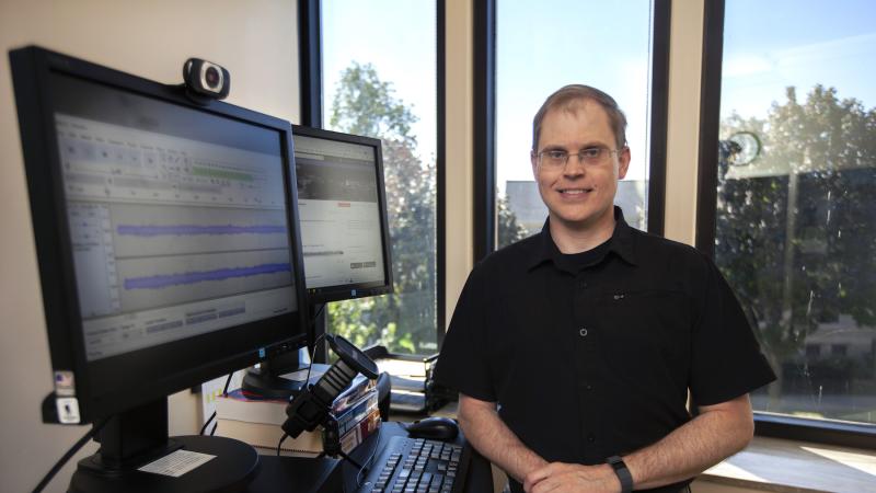 Ty Collins poses next to his computer.