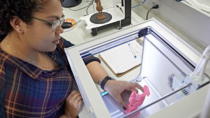 Student creates object using 3D printer in Lawrence's Makerspace studio