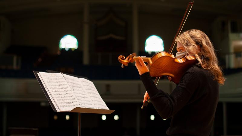Student playing violin in Memorial Chapel