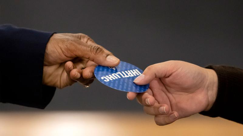 Laurie Carter, Lawrence University’s President, hands out a sticker while greeting students at the President’s Handshake in Memorial Chapel