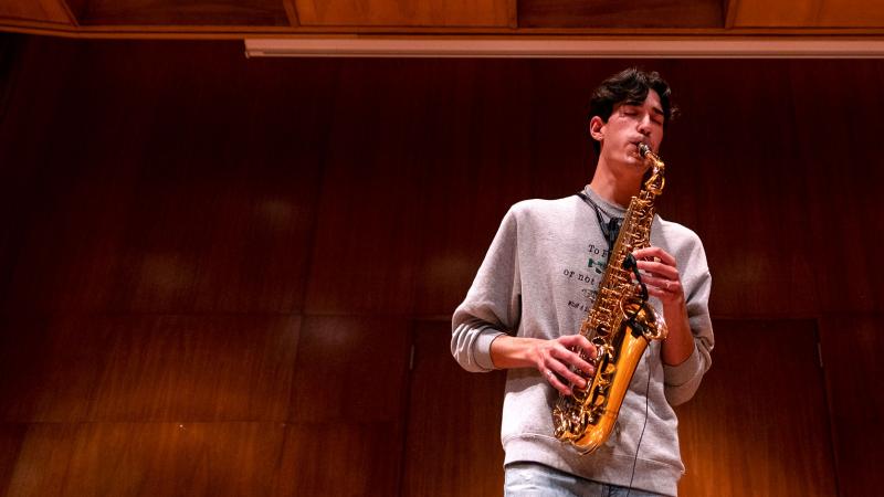 Student playing a saxophone on stage
