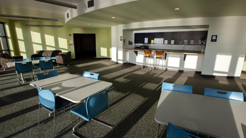 Large dining area in Hiett Hall kitchen with sunlight filtering in through the windows.