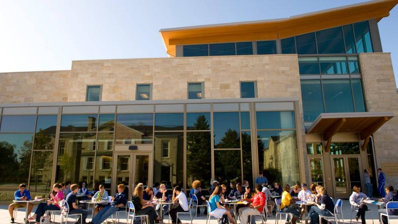 Exterior of Warch Campus Center with students sitting at tables