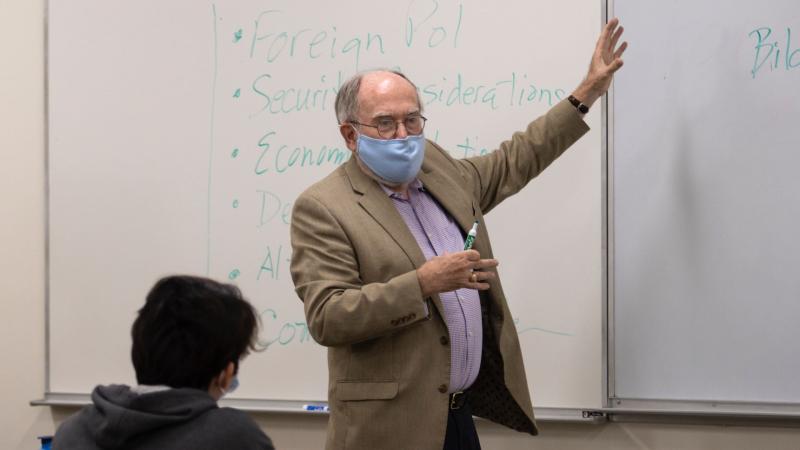 Shaun Donnelly, 2021's Visiting Scarff Professor, gestures towards the whiteboard with dry erase marker in hand.