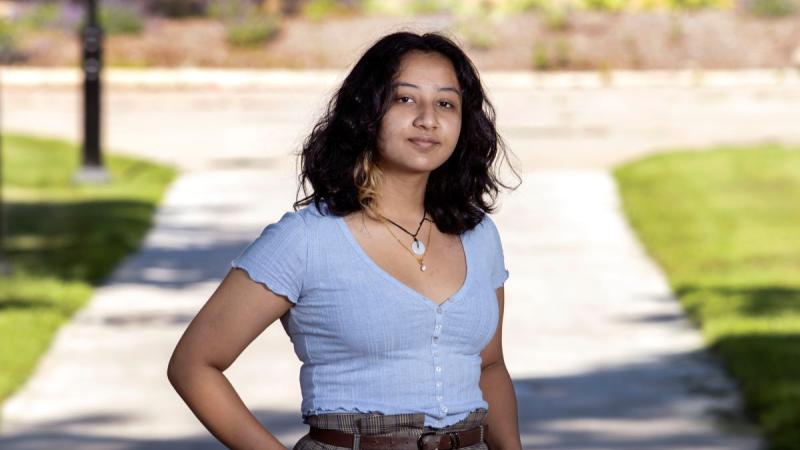 Tee Karki, wearing a purple shirt, poses on Main Hall Green.