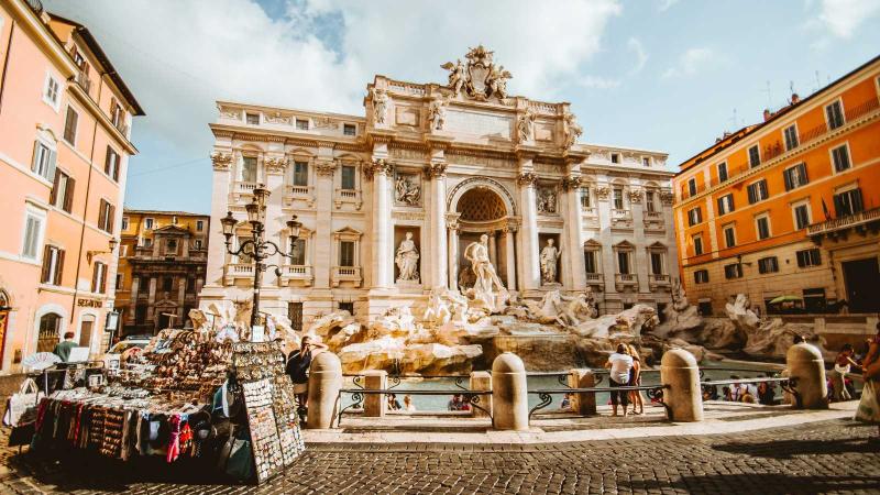 Trevi Fountain in Rome, Italy with trinket vendor in foreground