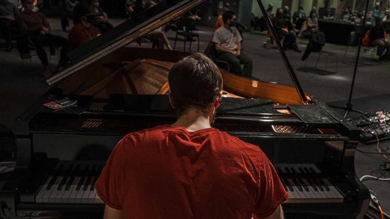 Image of a person playing a grand piano