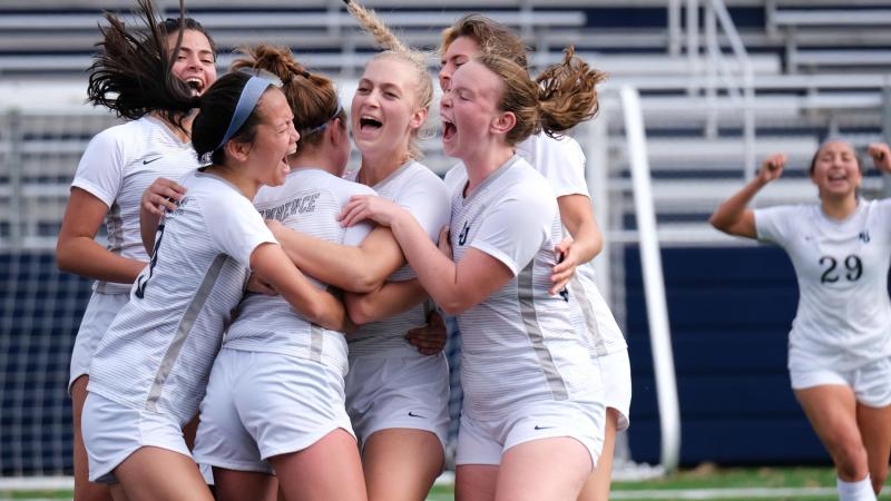 Teammates surround Lawrence University's Emma Vasconez after scoring a golden goal in overtime