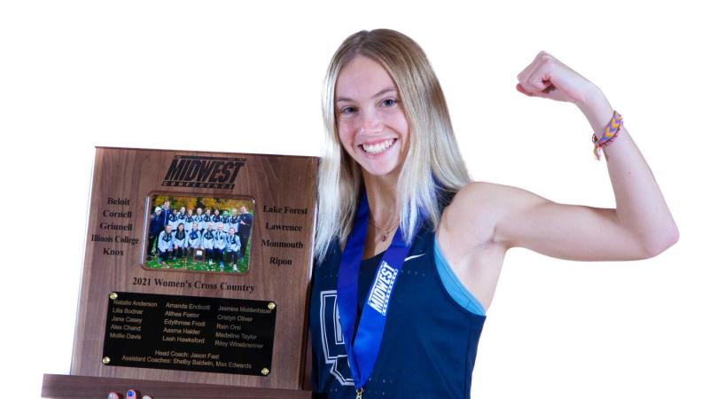 Cristyn Oliver poses with the 2021 Midwest Conference cross country championship trophy.