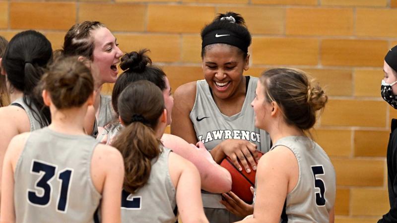 Kenya Earl holds the basketball while she celebrates with her teammates after setting the scoring record.