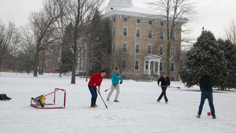 students play broomball on Lake Ormsby's ice rink