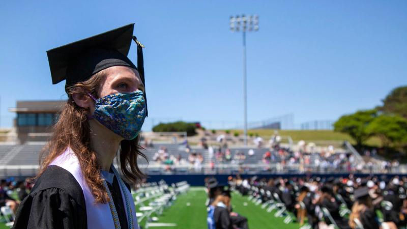 Graduate listens to Commencement ceremony in the Banta Bowl
