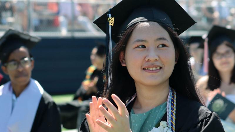 Graduate clapping at Commencement