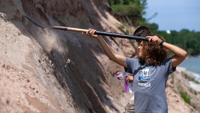 Student shoveling dirt.