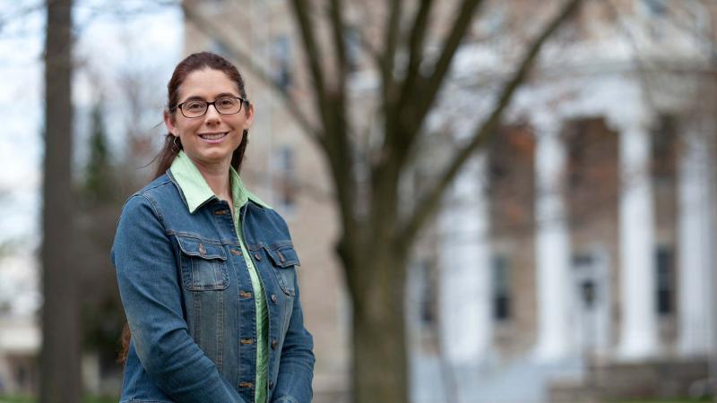 Alyssa Hakes, wearing a denim jacket, smiles at the camera.