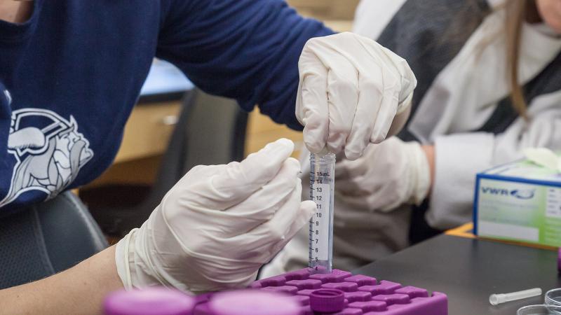 Student holding test tube in science lab