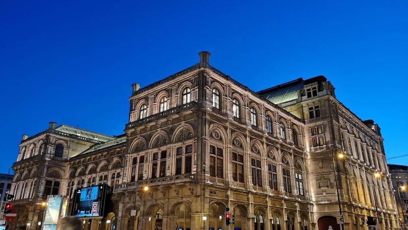 Crowd outside Vienna operahouse at dusk.