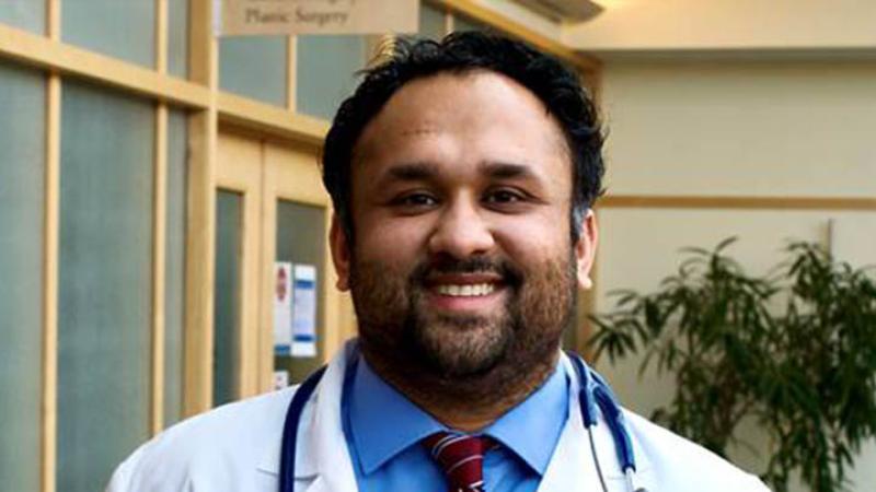 Dr. Mohit Gupta poses for a photo wearing his doctor jacket and stethoscope. 