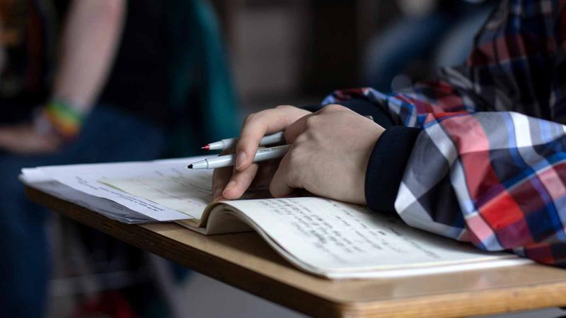 Student writing in notebook.