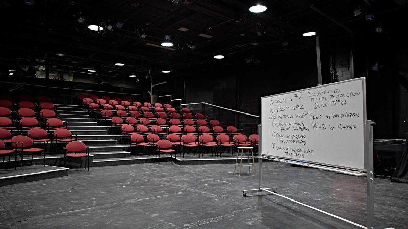 Empty theater with whiteboard on stage.