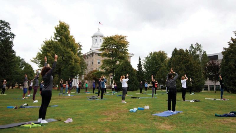 Students do outdoor yoga in front of Main Hall