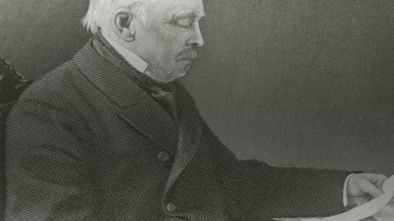 Amos Adams Lawrence, seated, looking at a piece of paper at his desk