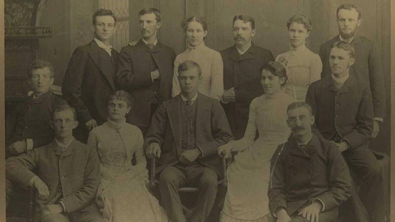 Men and women seated and standing for a class photo