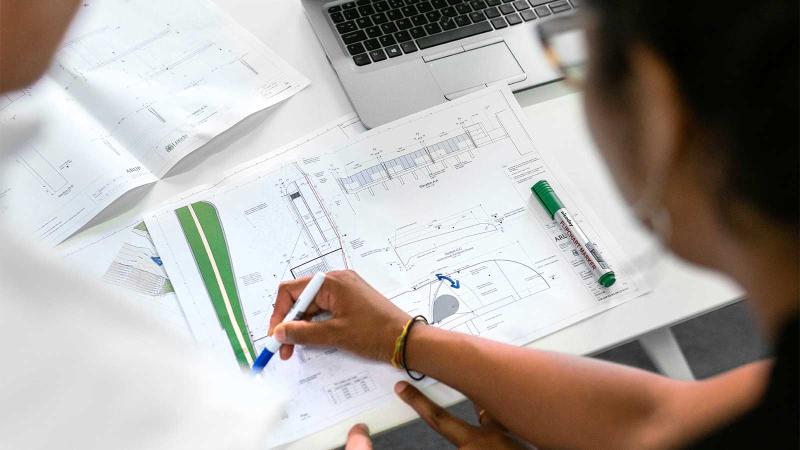 Engineers examining paperwork on a table