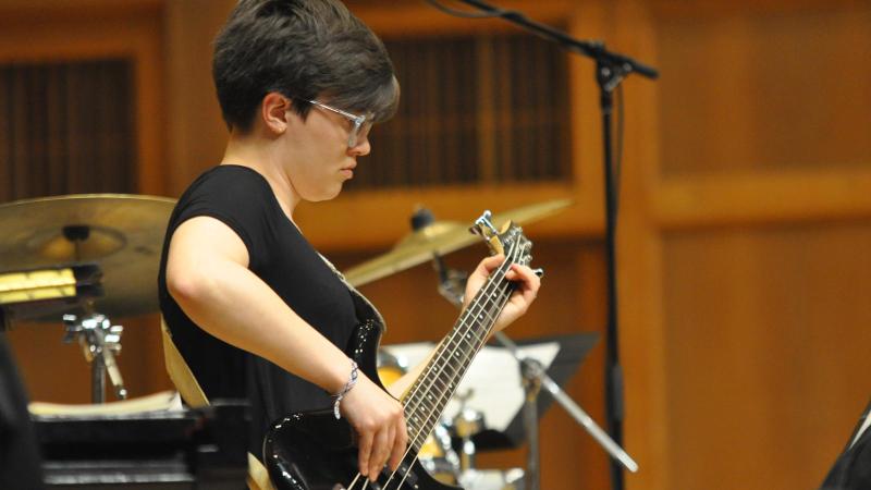 Student plays guitar on stage