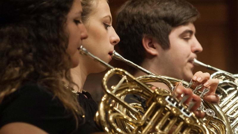 Three students playing horns