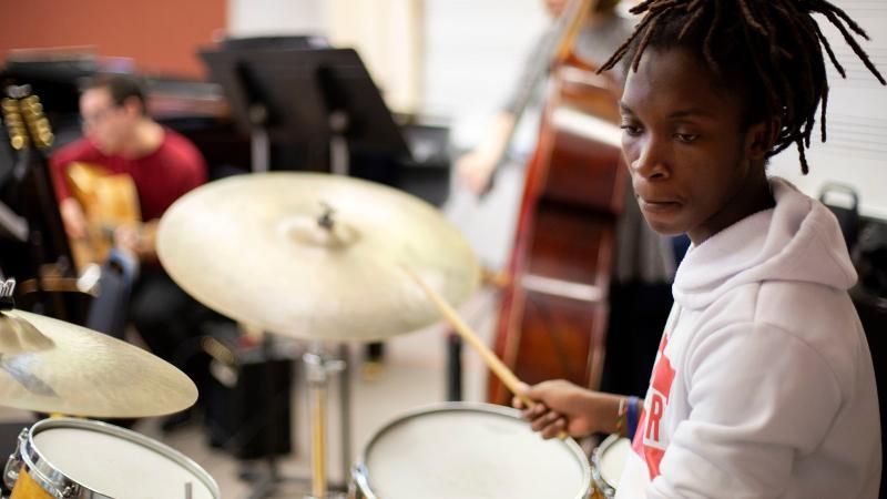 Student plays drums in classroom