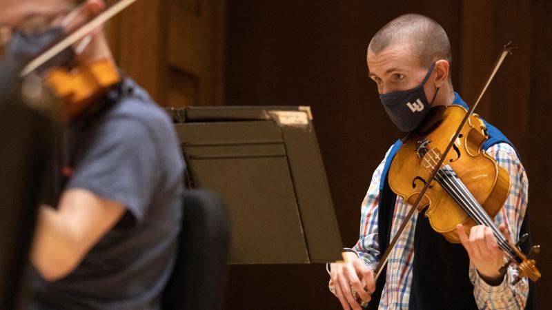 Student plays viola and is wearing an LU facemask