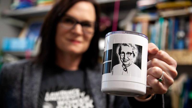 A black and white photo of Elda Anderson is featured on a white coffee mug held by Megan Pickett.