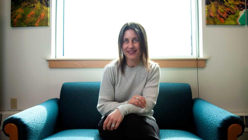 Professor Lori Hilt sits on a chair in her office as she poses for a portrait.