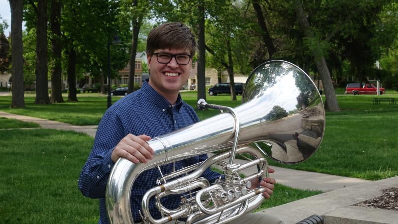 Henry holds a tuba.