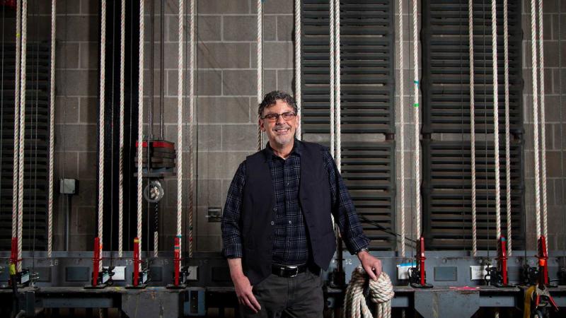 Timothy X. Troy stands back stage in Stansbury Theater.