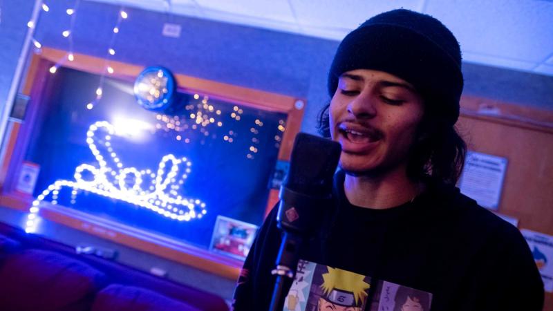 Xavier Yon sings into a microphone as he practices with VOODIS bandmates in SOL Studios.
