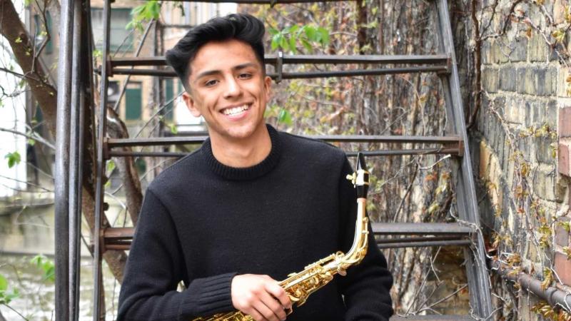 Luis Trejo poses with his saxophone.