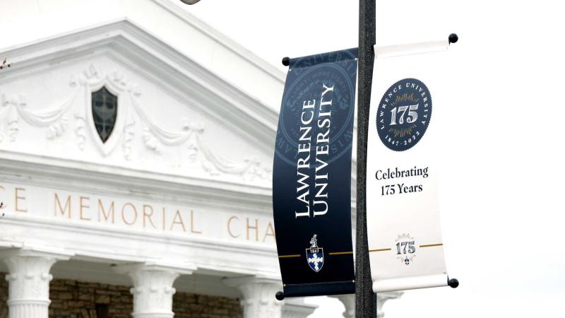 A banner celebrating Lawrence's 175 Years hangs on College Avenue with Memorial Chapel in the background.