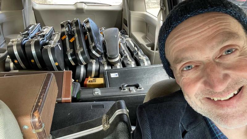 Brian Pertl takes a selfie with a van full of donated musical instruments.
