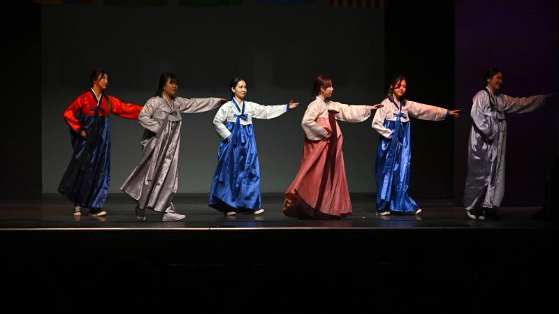 Students in traditional Korean outfits dance onstage during 2022 Cabaret.