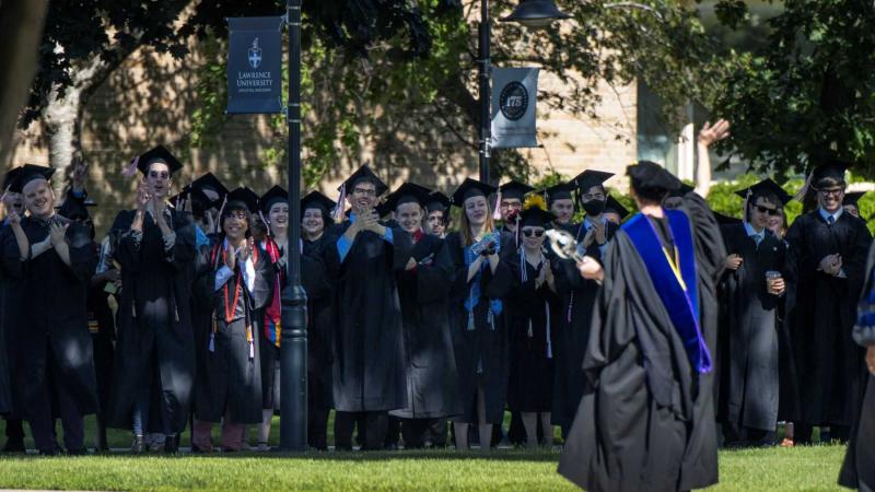 Graduates applaud the faculty as they walk the processional during 2022 Commencement.