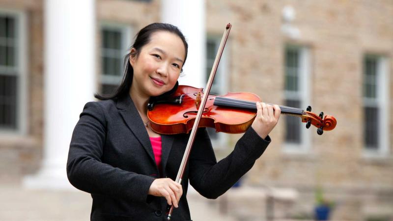 Wen-Lei Gu poses with her violin on Main Hall Green.