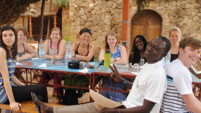 Senegal group sitting at outdoor table.