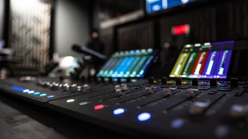 Audio console with multi-colored buttons and screens.