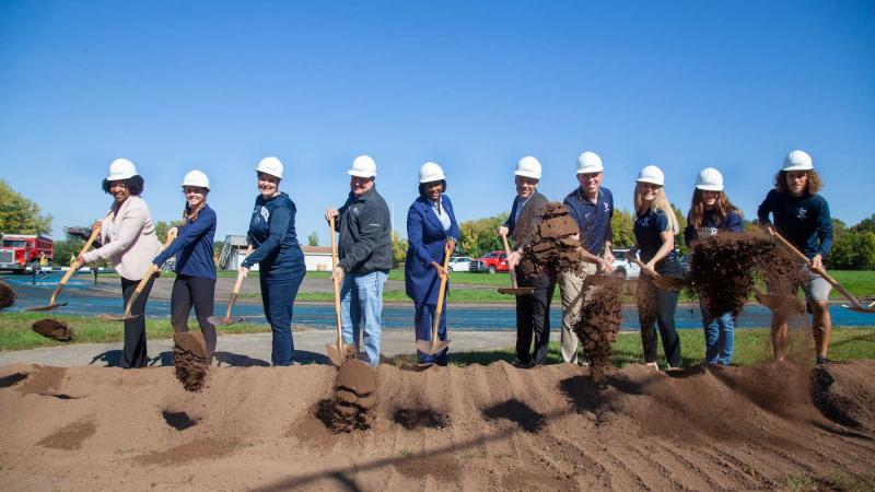 President Laurie Carter, the the center, joins other university and building officials with the first shovels of dirt at the Whiting Field Track.