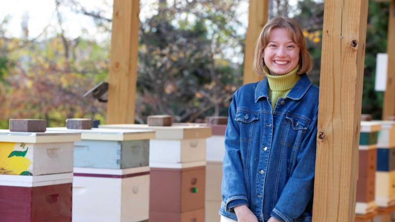 Biology major, Bella Goland poses for a photo in the apiary in Sustainable Lawrence University Garden.