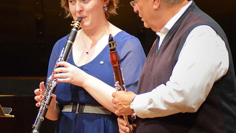 Student playing clarinet while faculty member provides feedback
