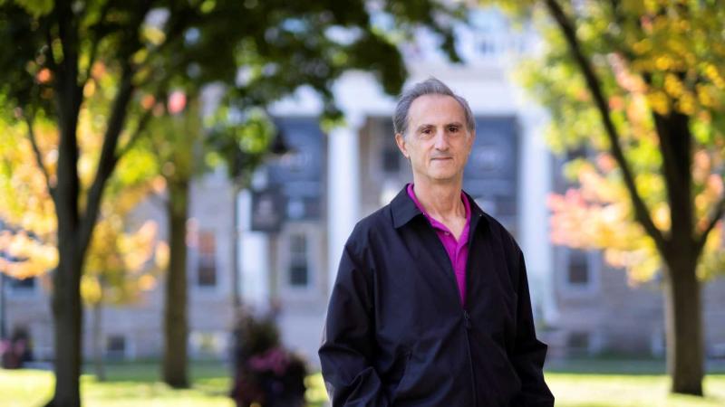 Gustavo Fares stands on the path leading from the front of Main Hall.