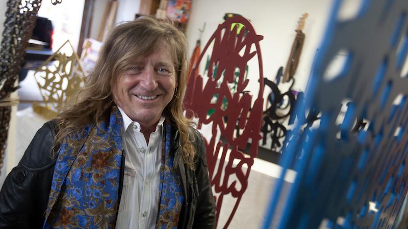 Rob Neilson stands amid artwork in his studio on campus.